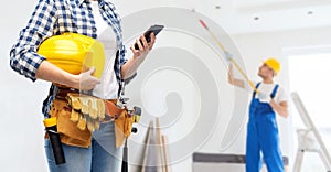 Woman or builder with phone and working tools