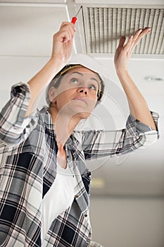 woman builder with screwdriver on ladder