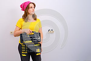 Woman builder shows a set of yellow construction tools, copy space