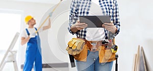 Woman or builder with tablet pc and working tools