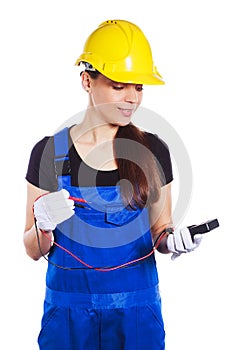 Woman builder in the uniform holds a multitester