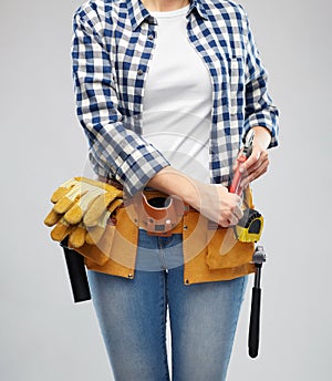 Woman or builder with working tools on belt