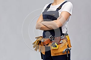 Woman or builder with working tools on belt