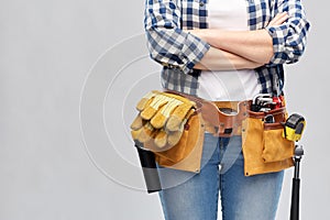 Woman or builder with working tools on belt