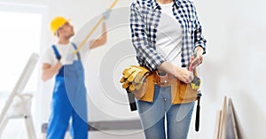 Woman or builder with working tools on belt