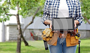 Woman builder with working tools showing tablet pc