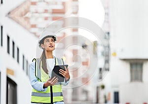 Woman, building and construction inspection on tablet working on site in the city for industry. Female architect