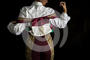 Woman bullfighter by dressing with vest on your back