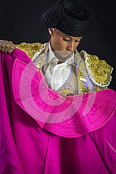Woman bullfighter holding capote pink