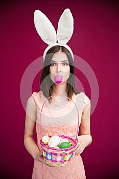 Woman in bunny ears holding Easter egg basket