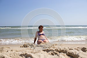 Woman buried in the sand on the beach