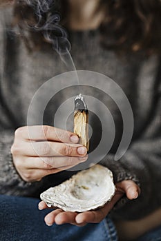 Woman buring palo santo for cleansing her home photo