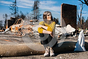 Woman at burned ruined house and yard, after fire disaster