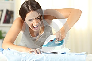 Woman burning a finger with a smoothing iron photo