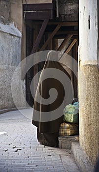 Woman with burqa waiting on a street in morocco