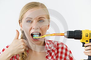 Woman burshing her teeth using drill