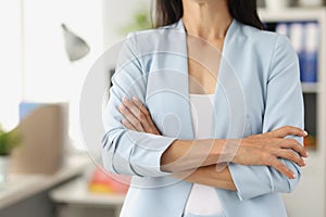 Woman in business blue suit standing with her arms crossed closeup