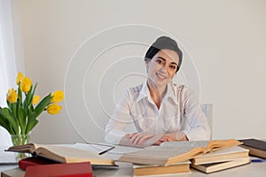 A woman in a business suit reads books in the Office