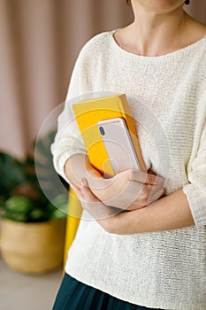 Woman businessman holding yellow notepad and smartphone