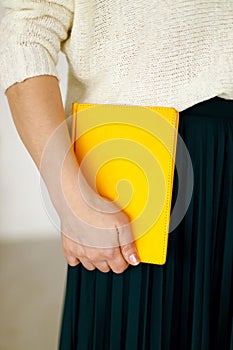 Woman businessman holding yellow notepad