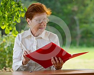 Woman of a businesswoman in age looks at documents.