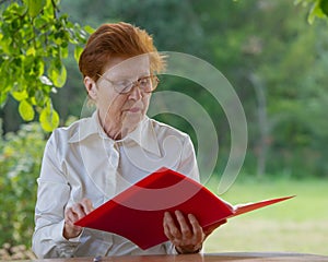 Woman of a businesswoman in age looks at documents.
