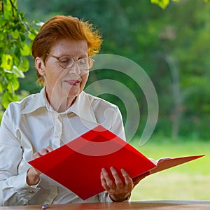 Woman of a businesswoman in age looks at documents