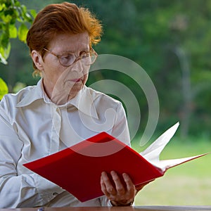 Woman of a businesswoman in age looks at documents.