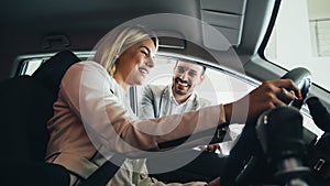 Woman buying a car in dealership sitting in her new auto