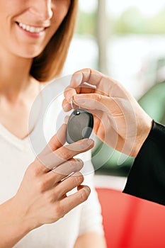 Woman buying car - key being given