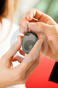 Woman buying car - key being given