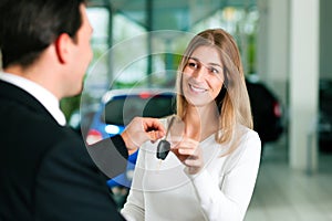 Woman buying car - key being given