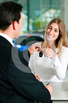 Woman buying car - key being given