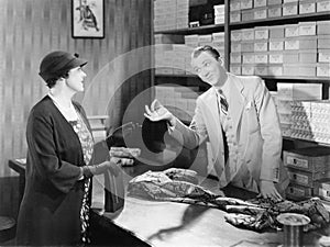 Woman buying fabric from a sales clerk at a department store