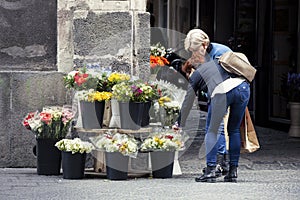 Woman buying flowers from street vendor