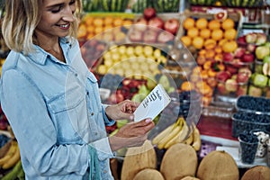 Woman buying food according to her shopping list stock photo