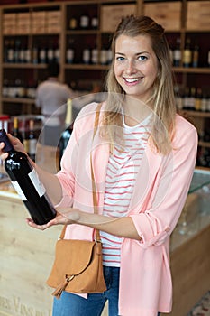 woman buying and holding bottle wine