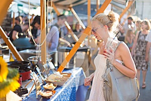 Woman buying meal at street food festival.