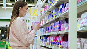 Woman is buying menstrual sanitary pads in hypermarket