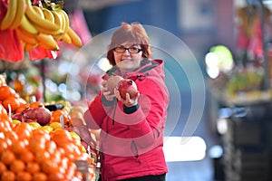 Woman buying nar fruit at market place photo
