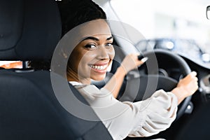 Woman Buying New Car Doing Test Drive In Dealership Store