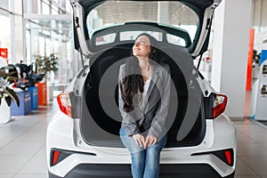 Woman buying new car, lady near the opened trunk