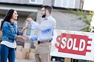 woman buying new house with sold signboard