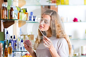 Woman buying perfume in shop or store photo