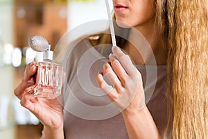 Woman buying perfume in shop or store