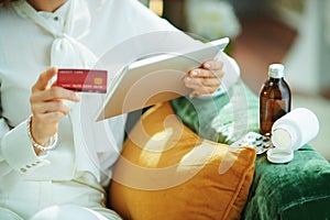 Woman buying pharma on tablet PC at home in sunny day