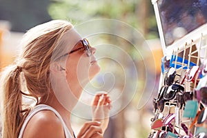 Woman, buying sunglasses and shopping at market outdoor in summer with consumer at flea store. Sales, person and