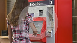 Woman buying ticket in ticketing machine