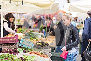 Woman buying vegetable at local food market.