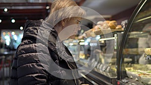 Woman in a cafe looking at a showcase with food
